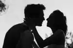 silhouette grayscale photo of man and woman attempting to kiss