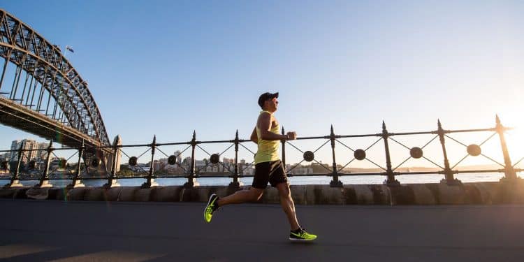 man in yellow tank top running near shore