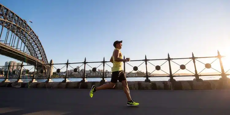 man in yellow tank top running near shore