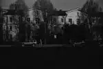 grayscale photo of cars parked near building