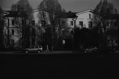 grayscale photo of cars parked near building